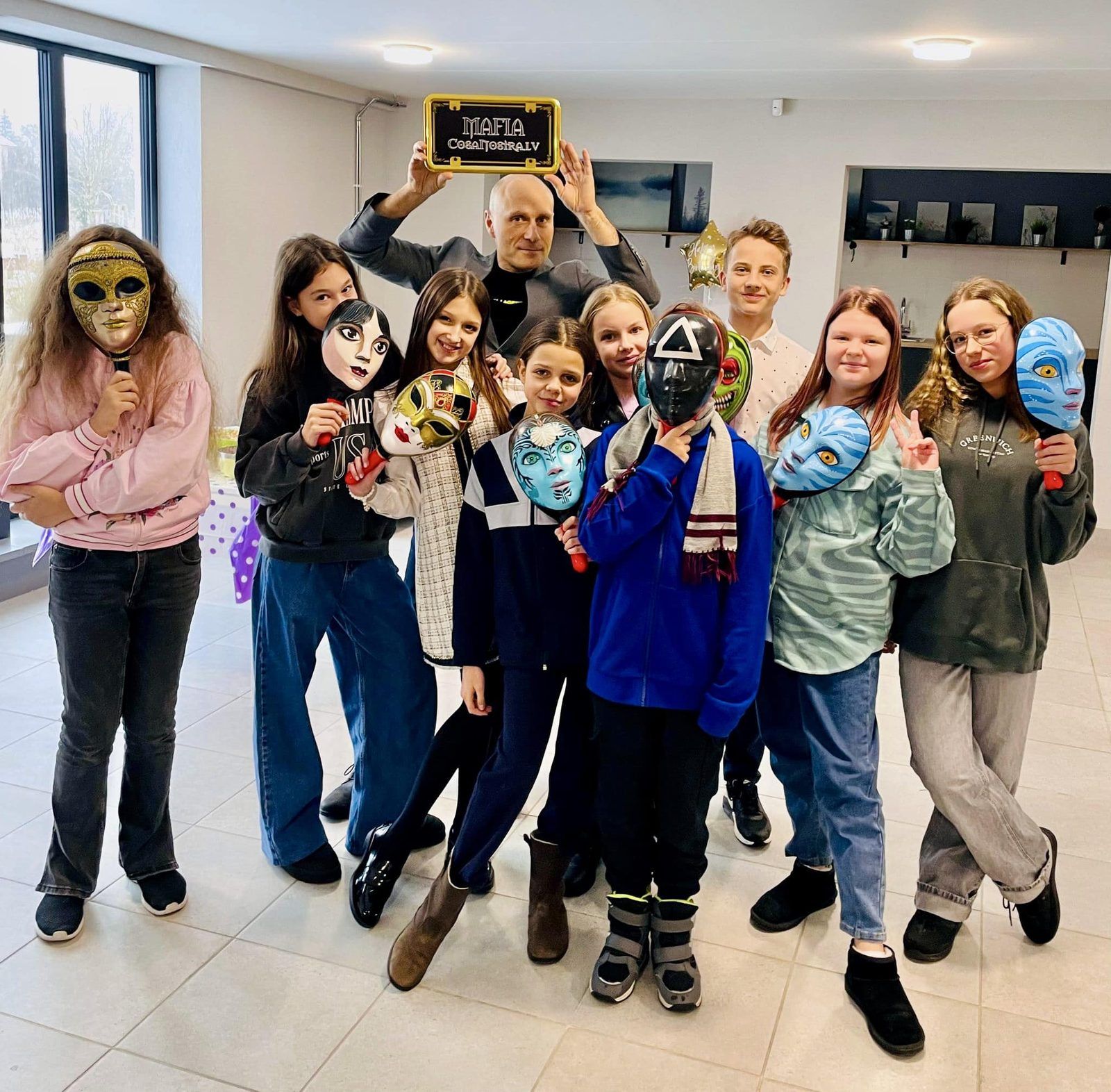 Skolēnu grupa ar spēles maskām